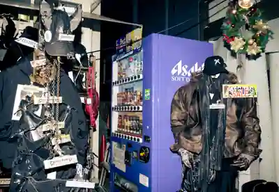 Purple Asahi vending machine beside a clothing display at night